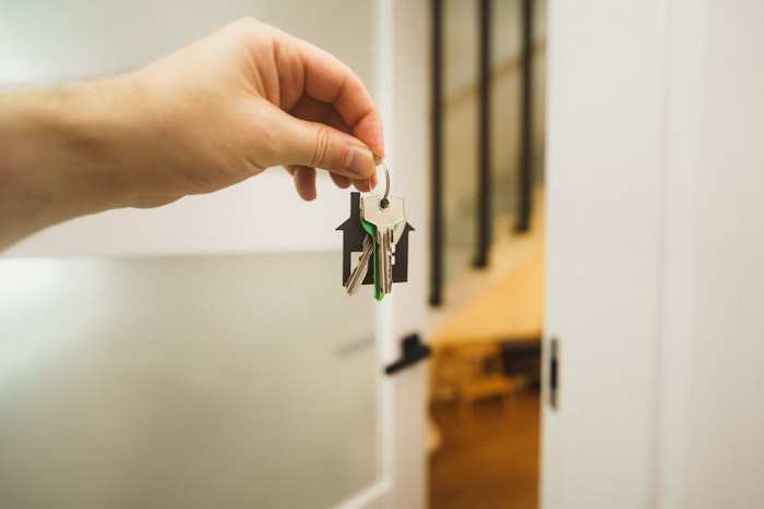 Hand holding keys for buy-to-let rental property